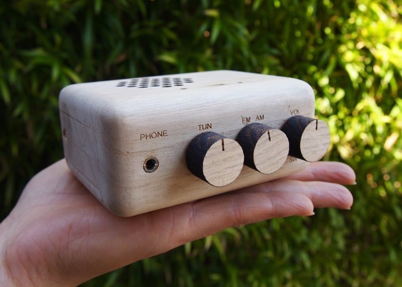 写真：手の上に乗る木で作られたラジオ