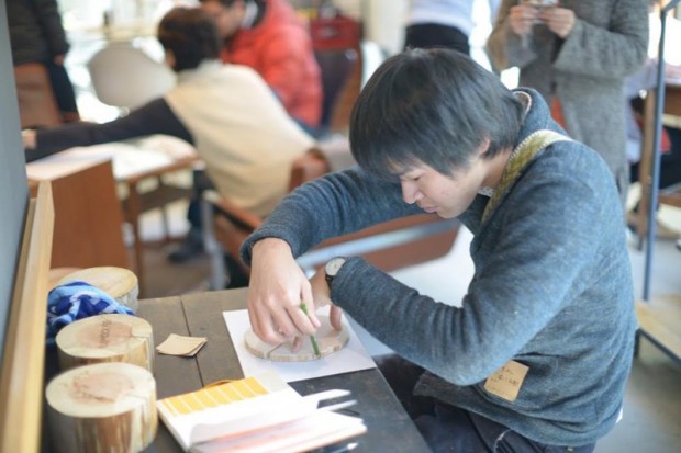 写真：木材の輪郭を鉛筆でなぞる参加者